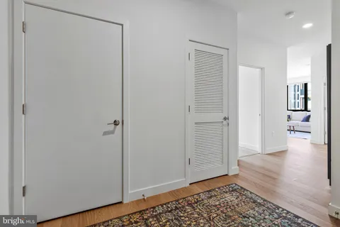 a view of a hallway with wooden floor and closet