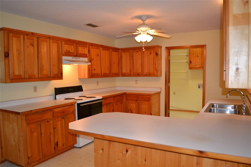 213 County Road 1997 Yantis, TX 75497 - Photo 14 of 28 a kitchen with a stove a sink dishwasher and a refrigerator