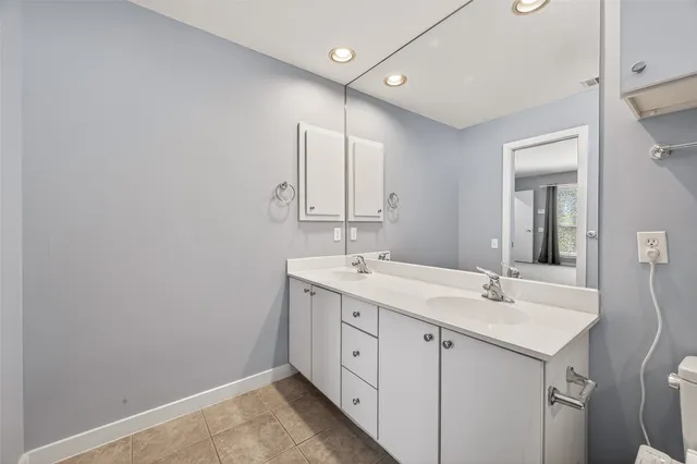 a bathroom with a granite countertop sink toilet a large mirror and shower
