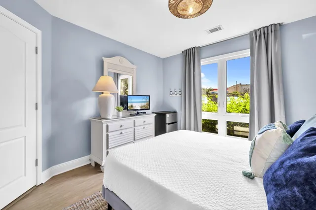 a bedroom with a bed and a dresser next to a window