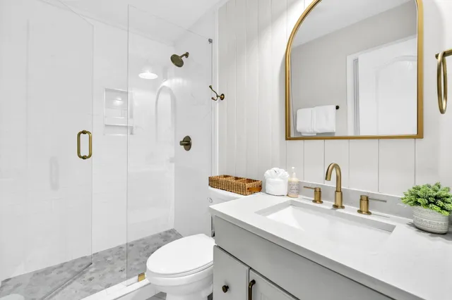 a bathroom with a sink a toilet and shower