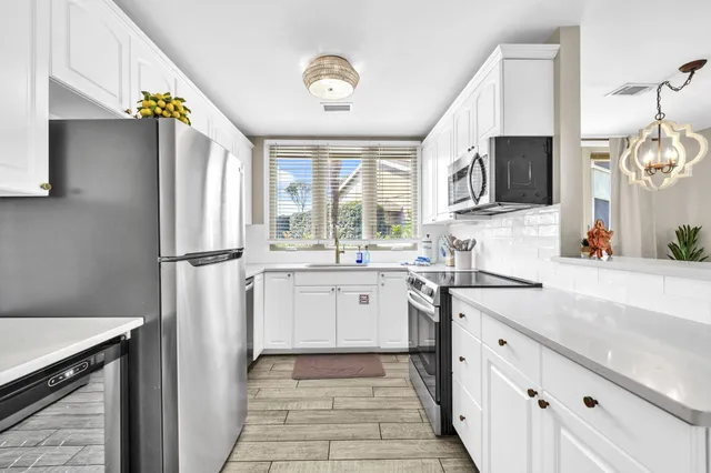 a kitchen with stainless steel appliances granite countertop a refrigerator and a sink