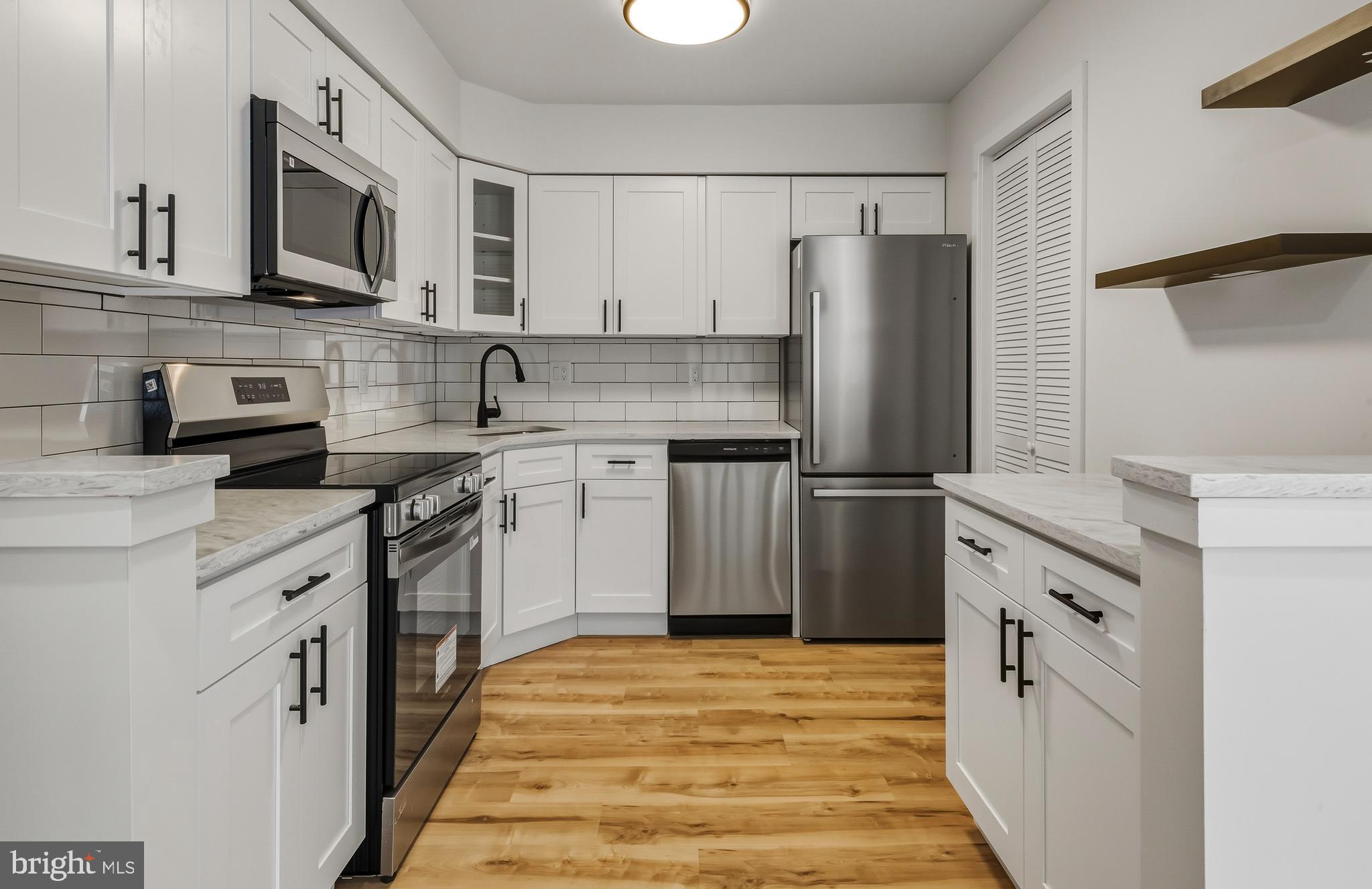 a kitchen with stainless steel appliances granite countertop a refrigerator stove a sink and dishwasher