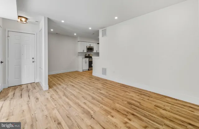 a view of empty room with wooden floor