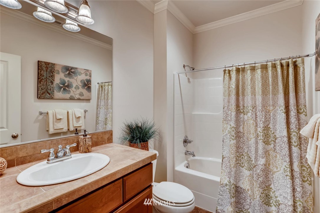 3110 222nd Street Southeast Bothell, WA 98021 - Photo 14 of 23 a bathroom with a granite countertop sink toilet a mirror a vanity a bath tub and shower