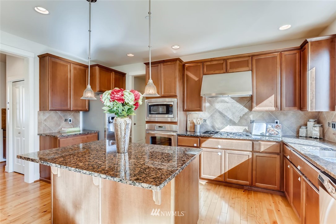 3110 222nd Street Southeast Bothell, WA 98021 - Photo 6 of 23 a kitchen with stainless steel appliances granite countertop a sink refrigerator and cabinets