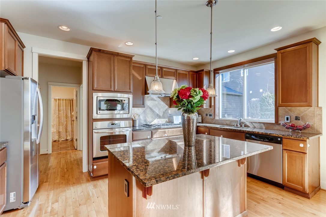 3110 222nd Street Southeast Bothell, WA 98021 - Photo 7 of 23 a kitchen filled with stainless steel appliances granite countertop a sink refrigerator and microwave