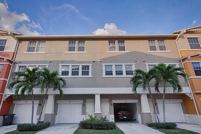 a front view of a house with garage and plants