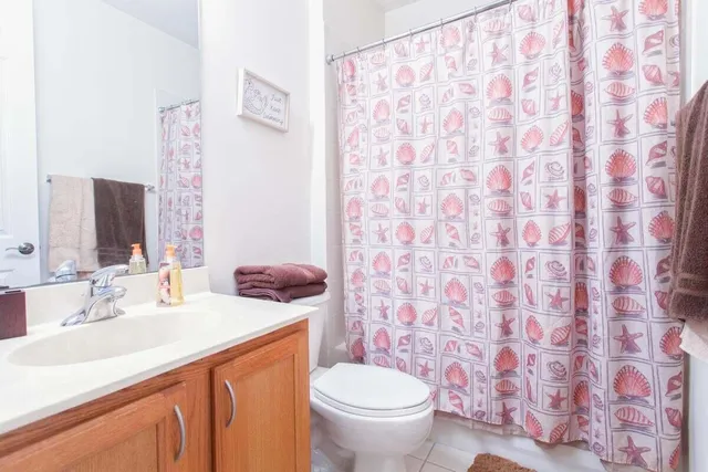 a bathroom with a granite countertop toilet sink and mirror