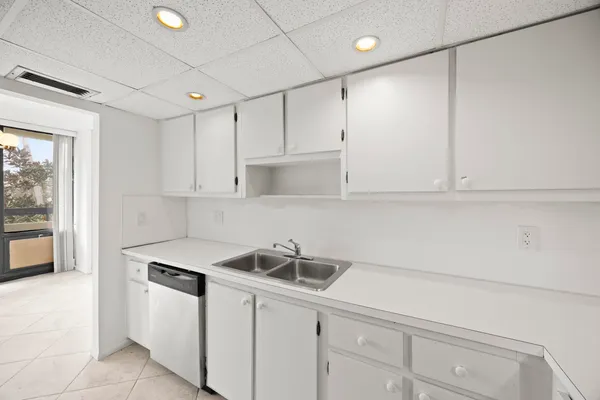a kitchen with white cabinets and white appliances