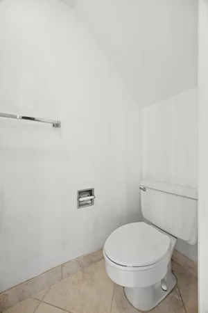 a white toilet sitting next to a shower