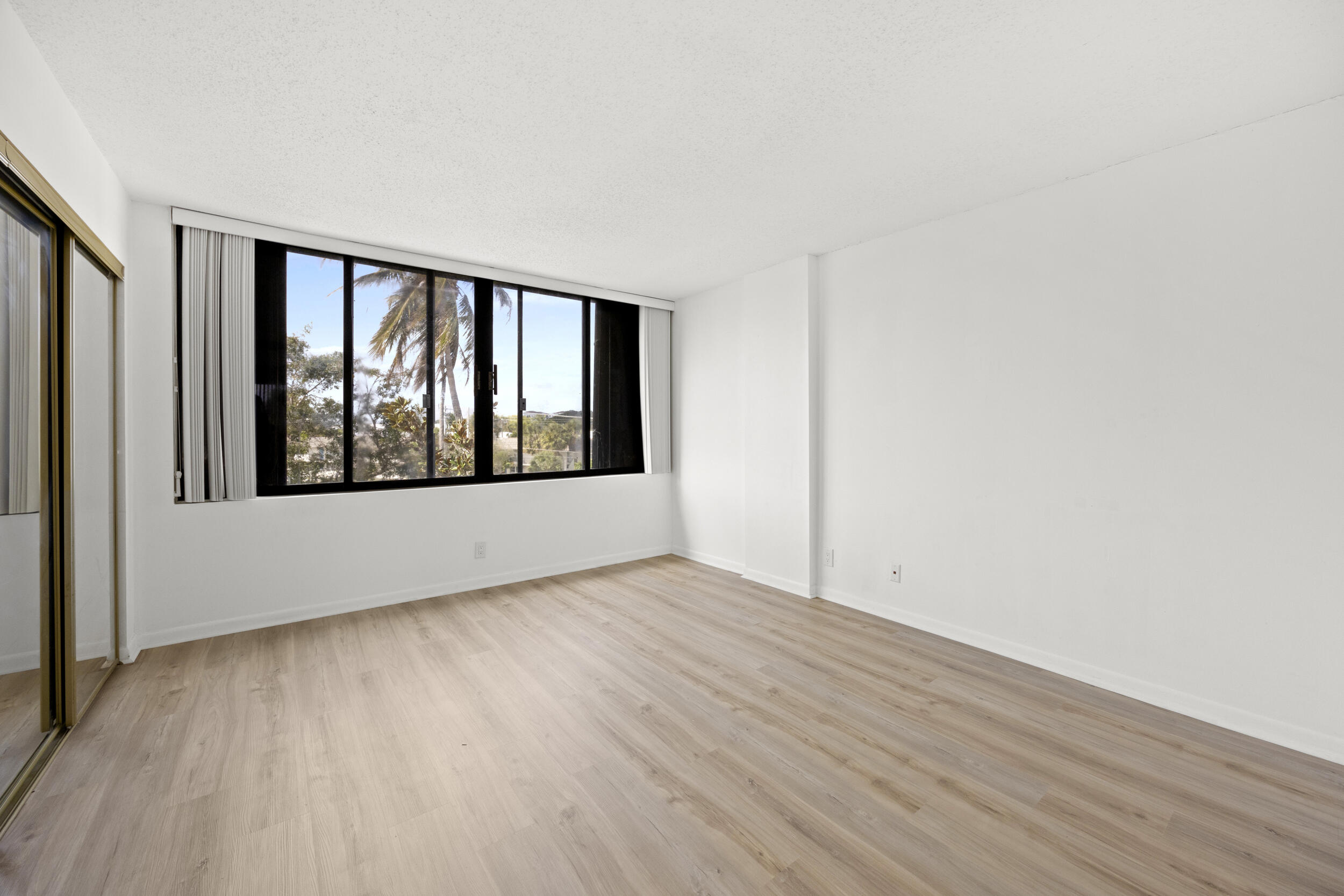 Undisclosed Address Boca Raton, FL 33432 - Photo 19 of 27 an empty room with wooden floor and windows