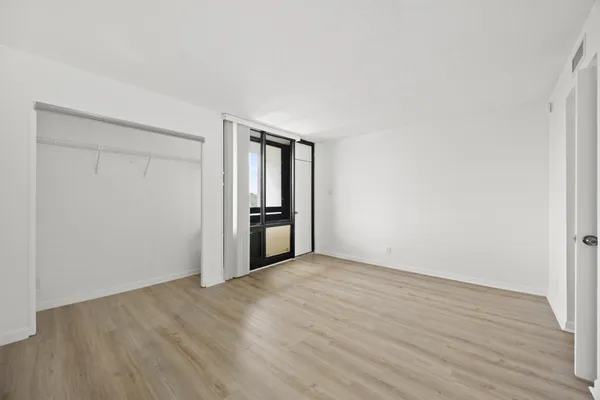 a view of an empty room with wooden floor