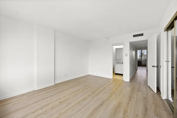 a view of empty room with wooden floor
