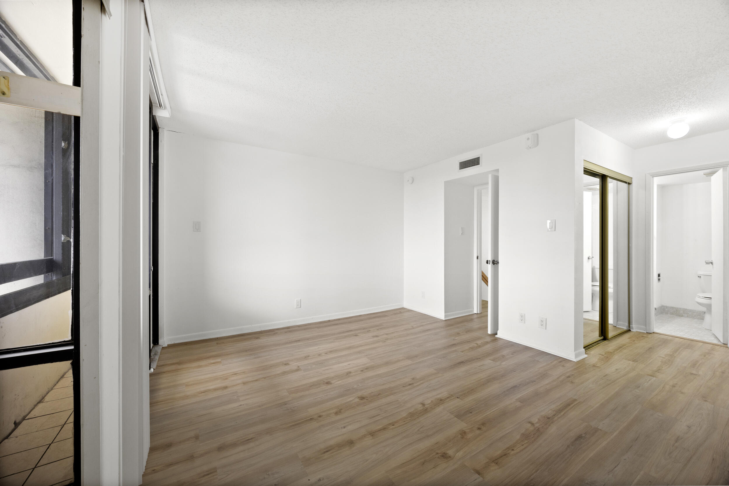 Undisclosed Address Boca Raton, FL 33432 - Photo 24 of 27 a view of an empty room with wooden floor and a window