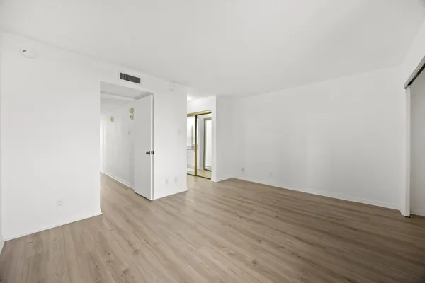 a view of an empty room with wooden floor