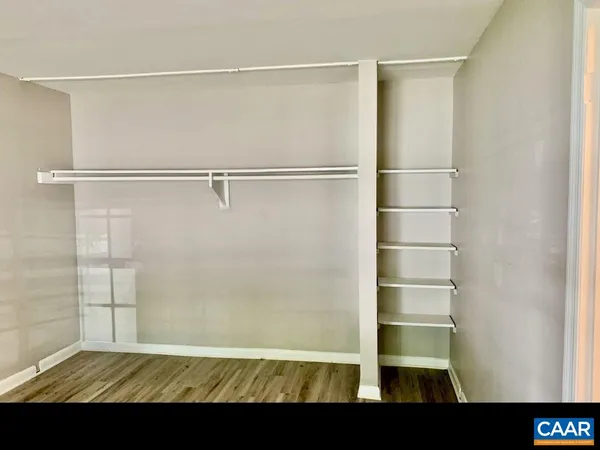 a view of walk in closet with empty racks