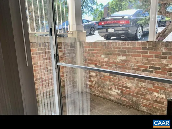 a view of a balcony with a couple of cars parked in front of house