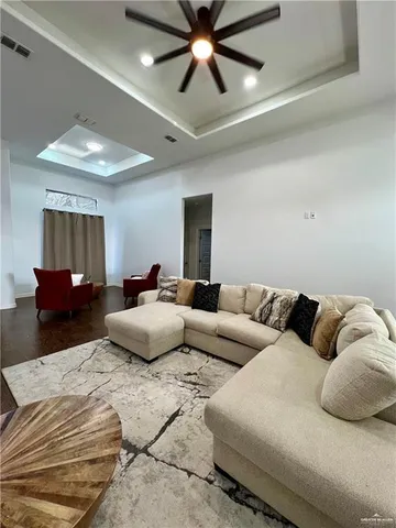 a living room with furniture and a ceiling fan