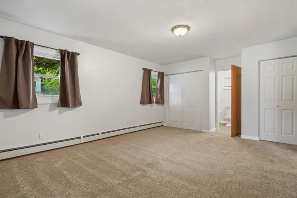 an empty room with windows and closet