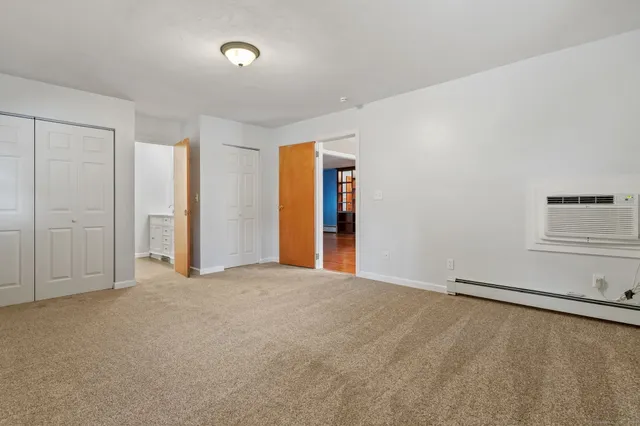 an empty room with windows and closet