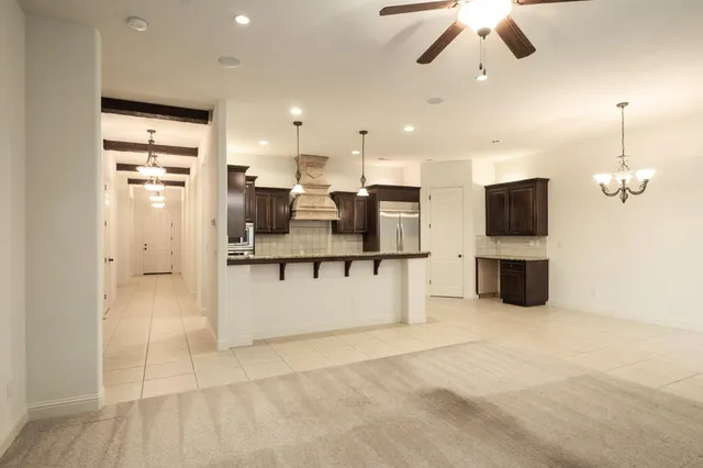 a large room with chandelier fan and windows