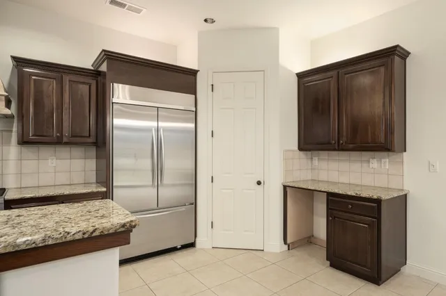 a kitchen with stainless steel appliances granite countertop a refrigerator and a sink