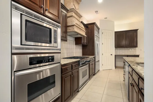 a kitchen with stainless steel appliances kitchen island a stove and a microwave