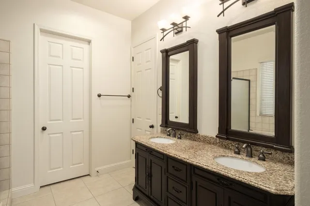 a bathroom with double sink and a mirror