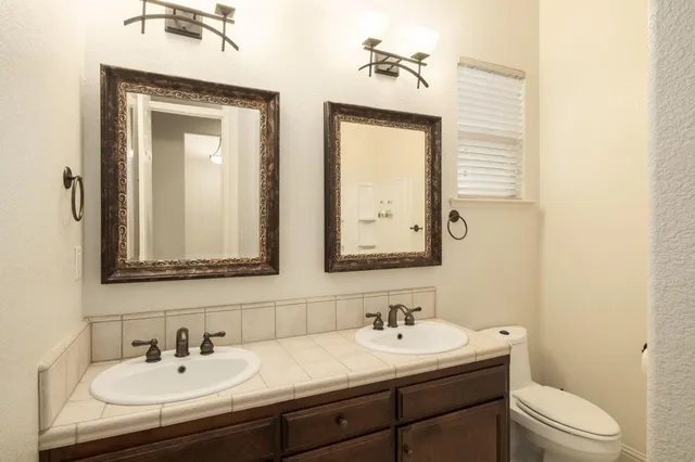 a bathroom with a toilet a sink and mirror