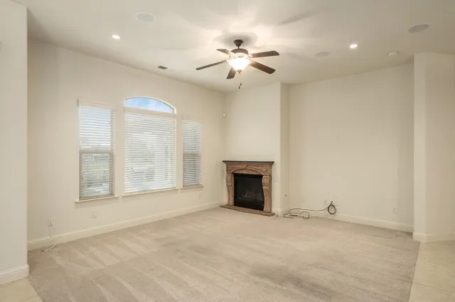 a view of an empty room with a fireplace and a window