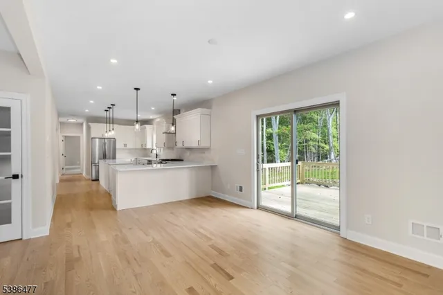 a large kitchen with stainless steel appliances granite countertop a large counter top and a wooden floors