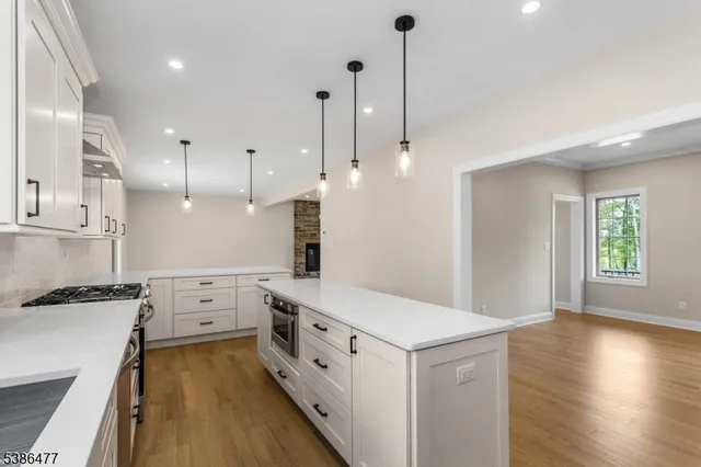 a kitchen with stainless steel appliances sink stove and wooden floor