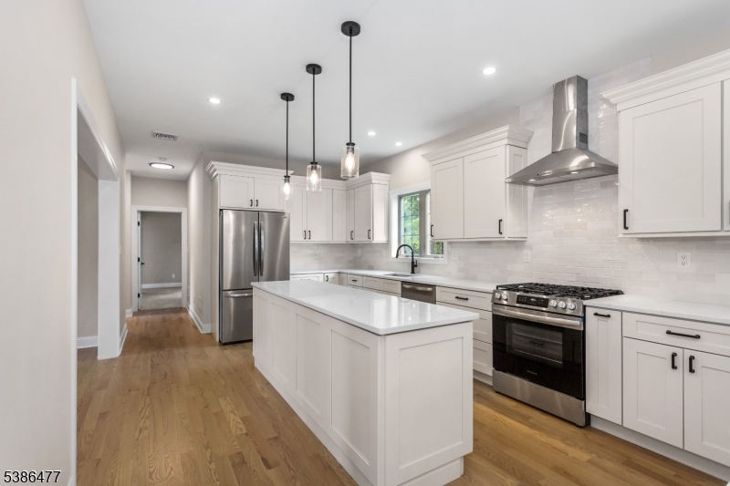 5 Percy Place Andover, NJ 07821 - Photo 17 of 50 a kitchen with stainless steel appliances kitchen island a stove a refrigerator a sink and a wooden floor