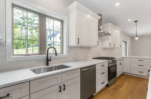 a kitchen with granite countertop a sink stainless steel appliances and window