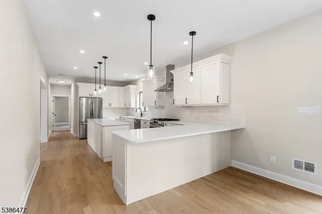 a large kitchen with a large counter top a sink a stove and a wooden floors