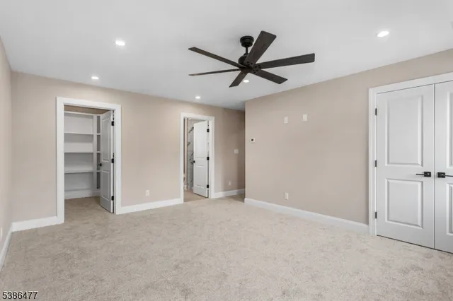 a view of an empty room and a ceiling fan