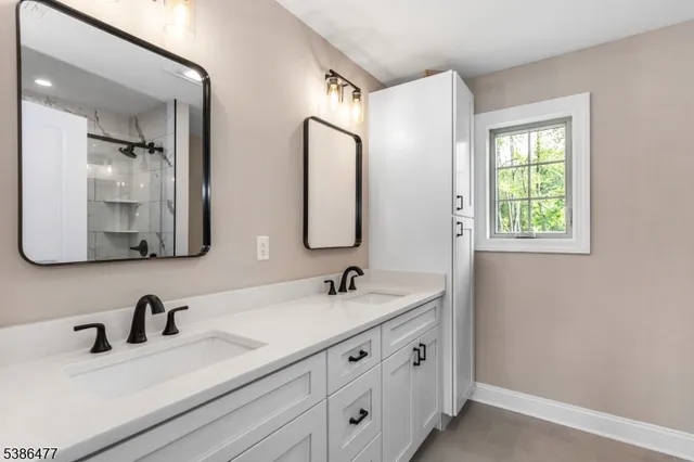 a bathroom with double vanity sinks and a mirror