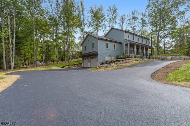 a view of a house with a big yard and large trees