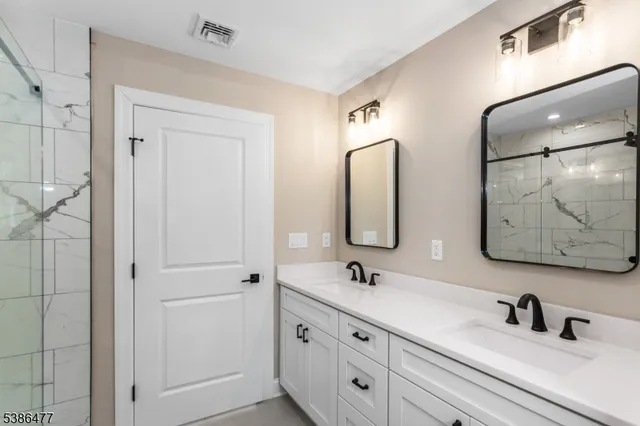 a bathroom with double vanity sinks and a mirror