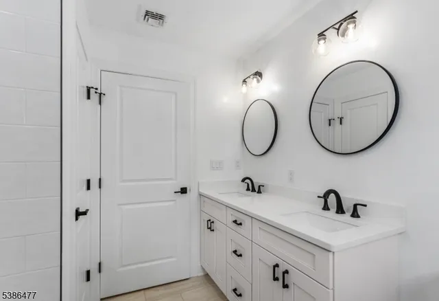 a bathroom with a double vanity sink and a mirror