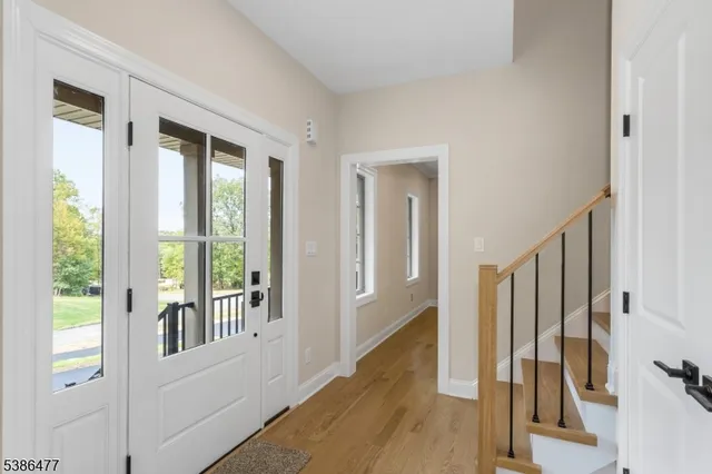 a view of a hallway with wooden floor and staircase