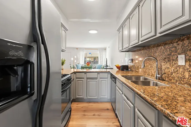a kitchen with stainless steel appliances granite countertop a sink stove and refrigerator