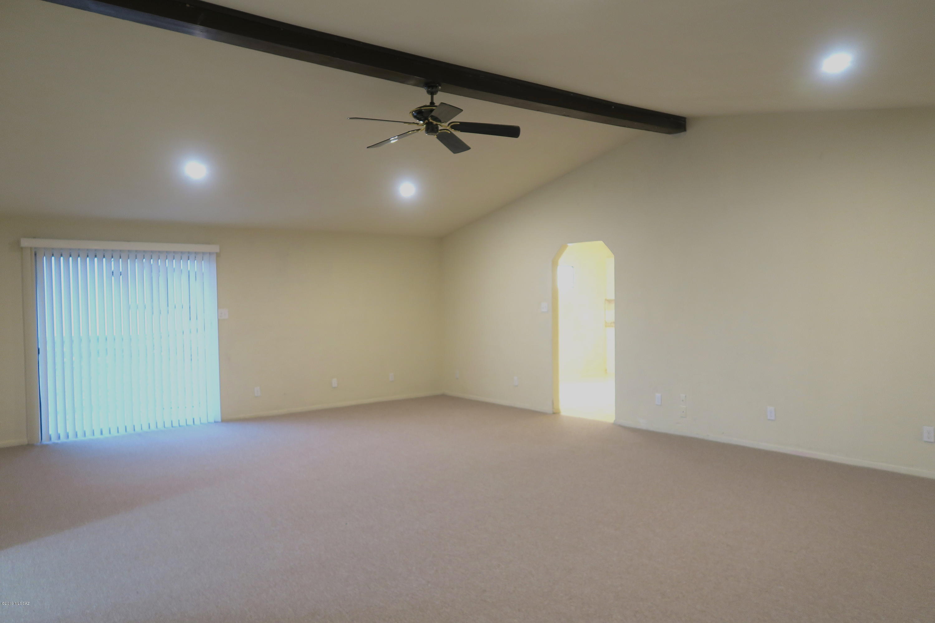 410 Sykes Circle Rio Rico, AZ 85648 - Photo 13 of 13 an empty room with a projector and a ceiling fan