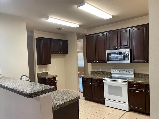 a kitchen with granite countertop wooden cabinets and stainless steel appliances