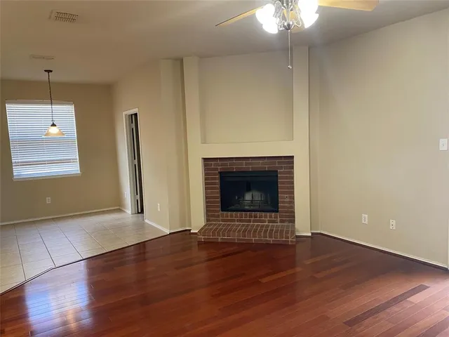 a view of a livingroom with wooden floor a fireplace and window