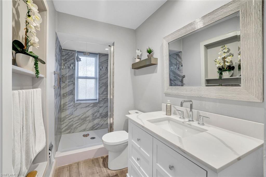 54 Hilo Court, Unit 54 Naples, FL 34112 - Photo 10 of 17 Fully renovated bathroom with walk-in shower featuring upgraded tile and all new fixtures.
