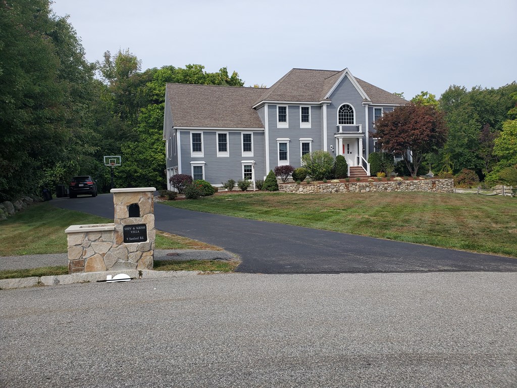 9 Sanford Road Chelmsford, MA 01824 - Photo 1 of 2 a front view of a house with a yard and garage
