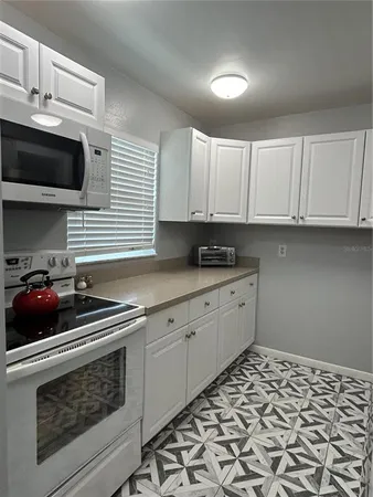a kitchen with stainless steel appliances a stove a sink and a microwave