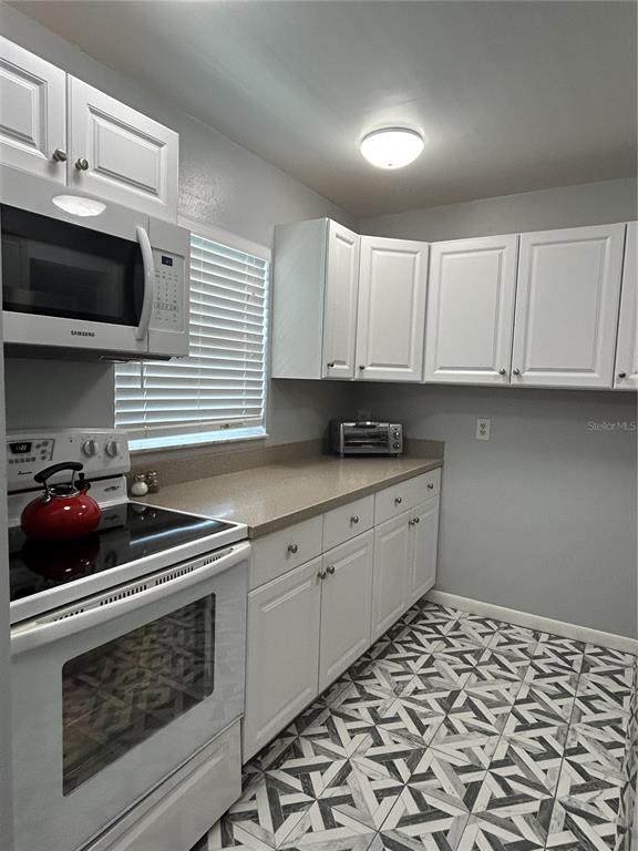 11485 Oakhurst Road, Unit 200307 Largo, FL 33774 - Photo 7 of 43 a kitchen with stainless steel appliances a stove a sink and a microwave